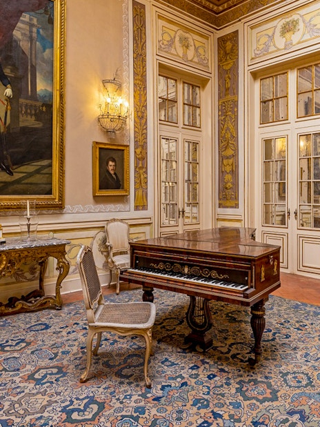 National Palace of Queluz Lantern Room with ornate furniture and large portrait.