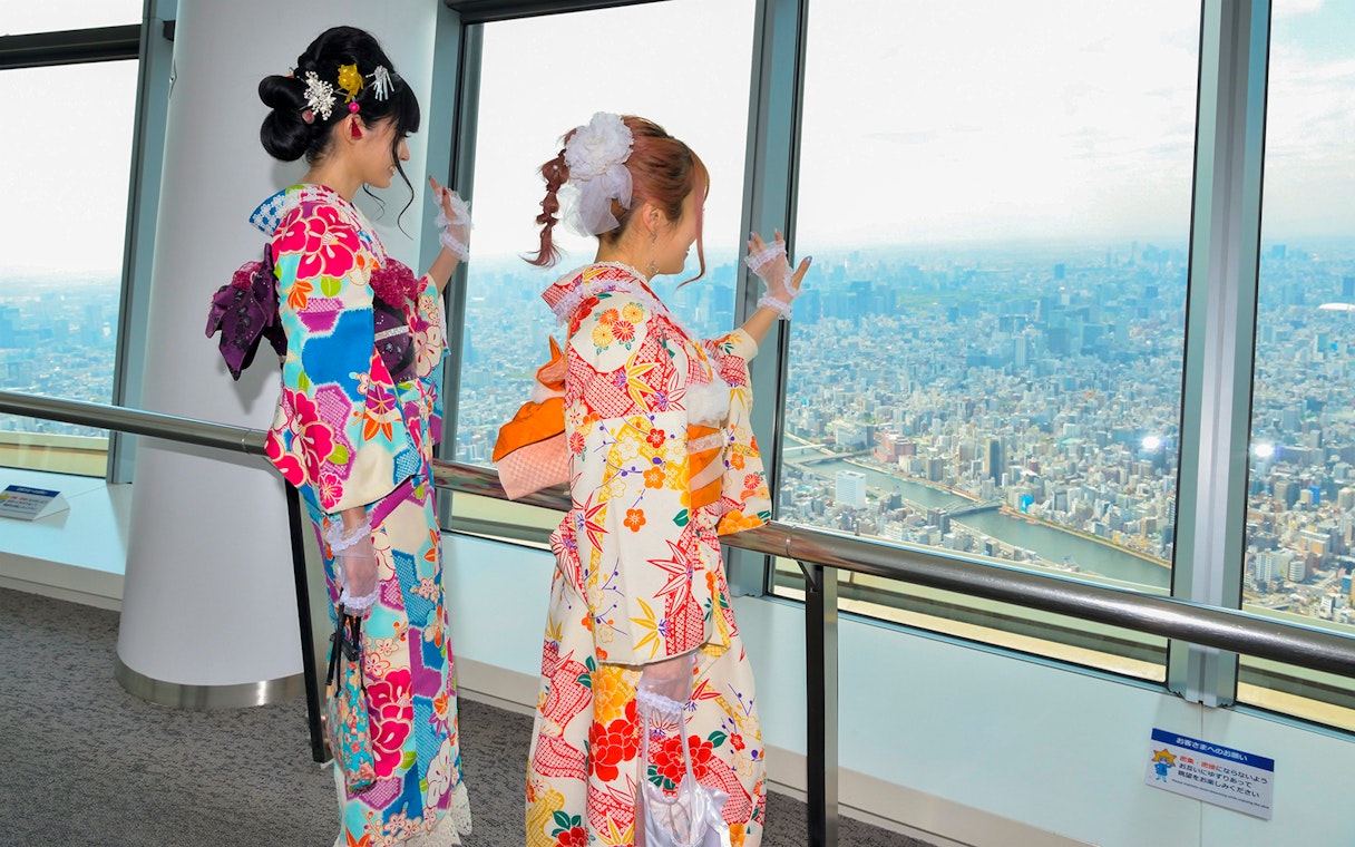 Visitors in kimonos enjoying the view from Tokyo Skytree observation deck.
