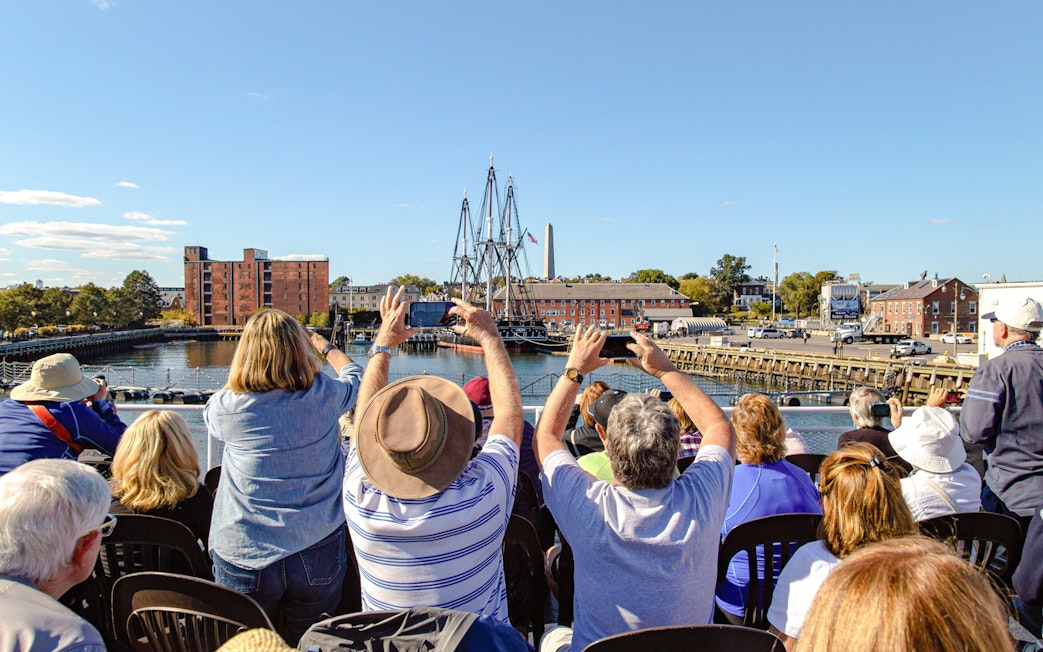 Tourists photographing the USS Constitution in Boston Harbor.