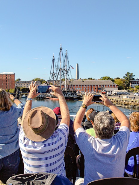 Tourists photographing the USS Constitution in Boston Harbor.