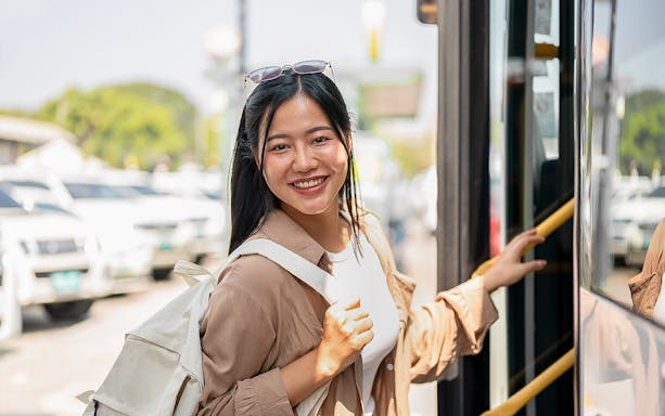 Woman boarding a bus to Nami Island with a backpack.
