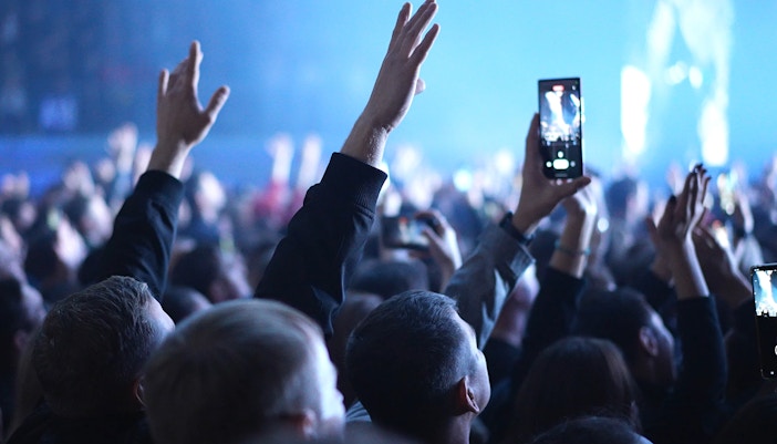 Crowd enjoying a live concert in Dubai, with hands raised and phones recording.
