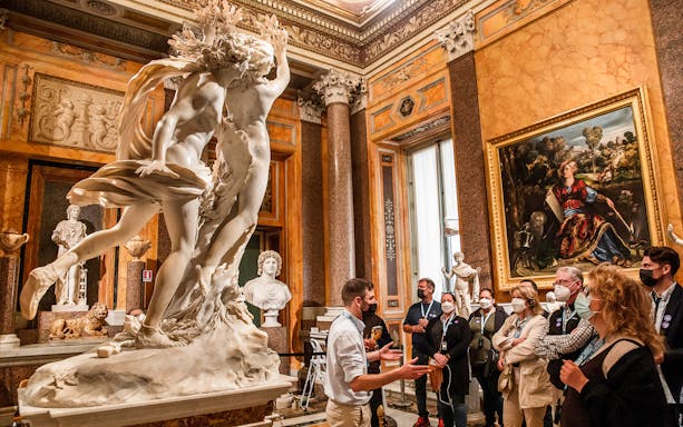 Borghese Gallery visitors view Bernini's Apollo and Daphne sculpture in Rome.