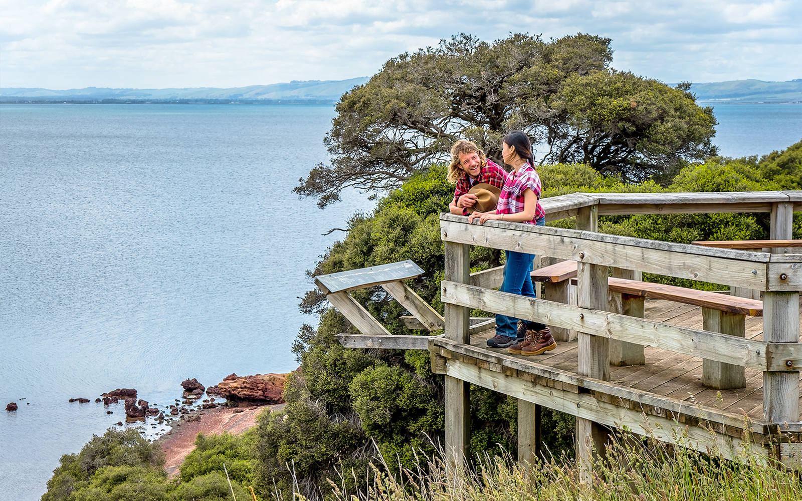 Visitors enjoying a scenic view from a wooden lookout on Churchill Island trail.