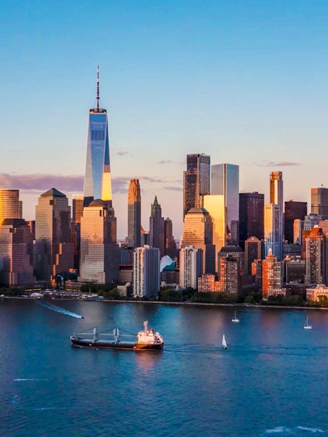 Aerial view of New York City skyline with One World Trade Center at sunset.