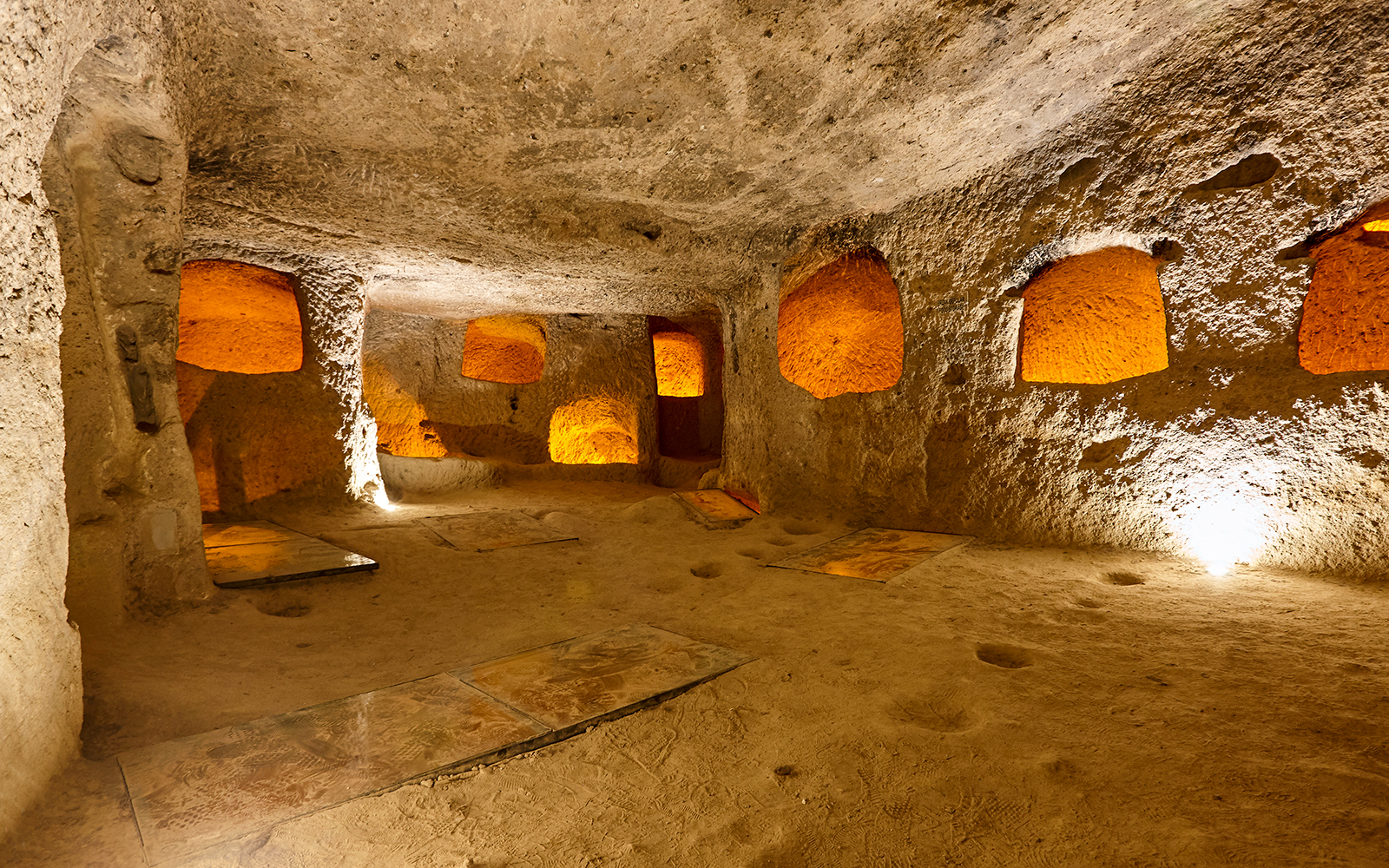 Maze of caves in Derinkuyu Underground City, Cappadocia, with illuminated stone walls.