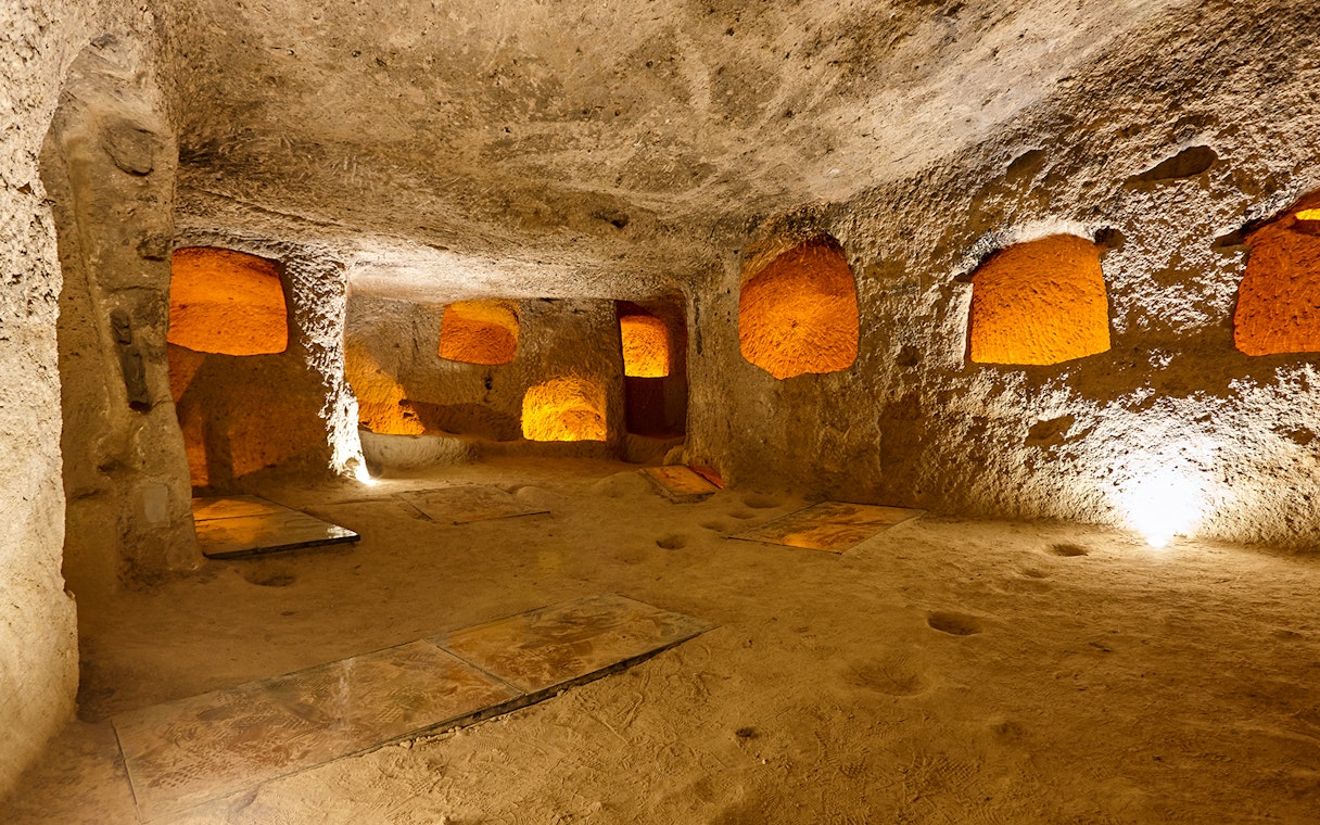 Maze of caves in Derinkuyu Underground City, Cappadocia, with illuminated stone walls.