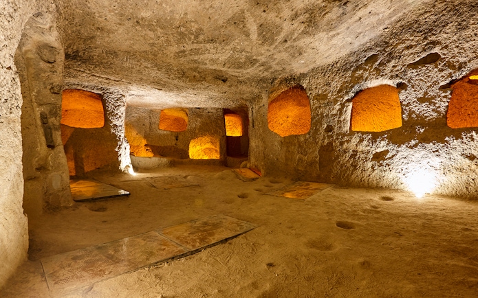 Maze of caves in Derinkuyu Underground City, Cappadocia, with illuminated stone walls.