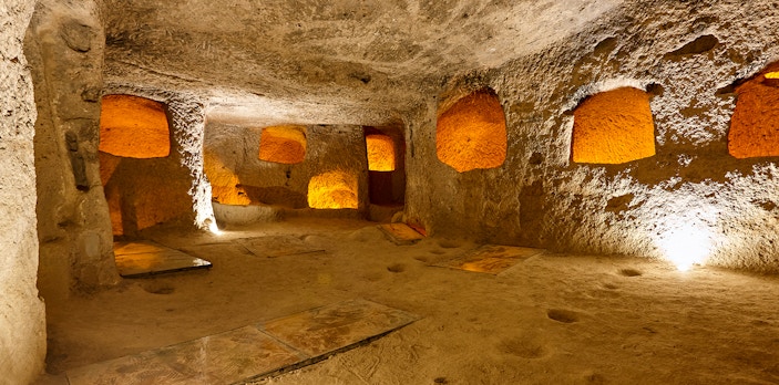 Maze of caves in Derinkuyu Underground City, Cappadocia, with illuminated stone walls.