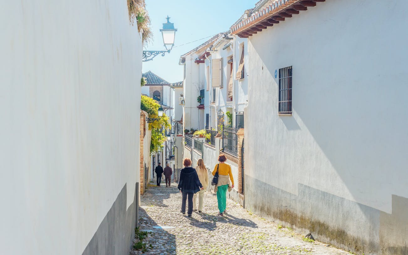 Walking through narrow cobblestone streets in Albaicin de Granada.
