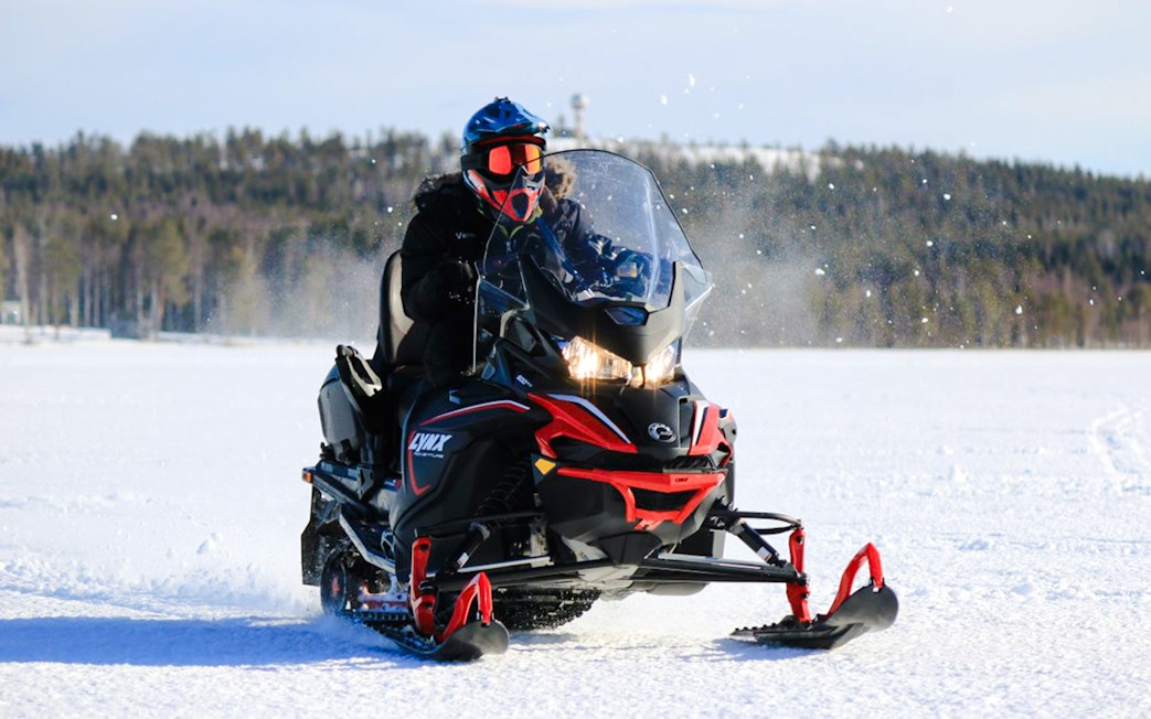 Snowmobile rider on snowy terrain during safari adventure in Rovaniemi.