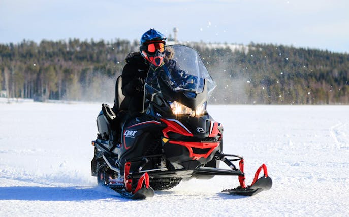 Snowmobile rider on snowy terrain during safari adventure in Rovaniemi.