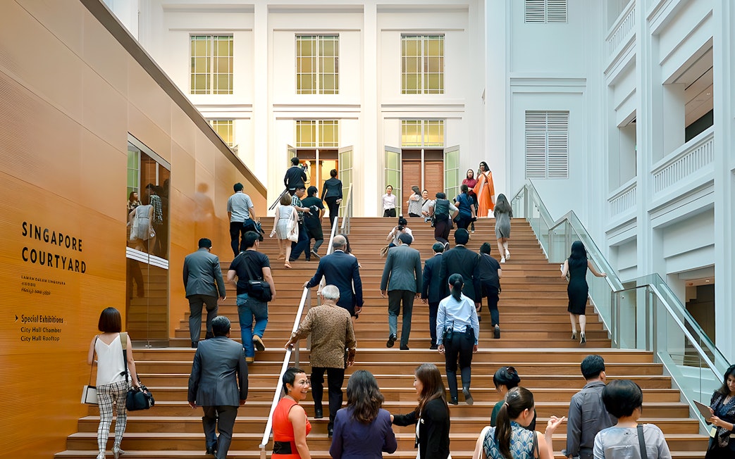 Guests ascending steps at National Gallery Singapore courtyard.