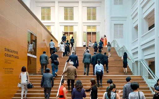 Guests ascending steps at National Gallery Singapore courtyard.