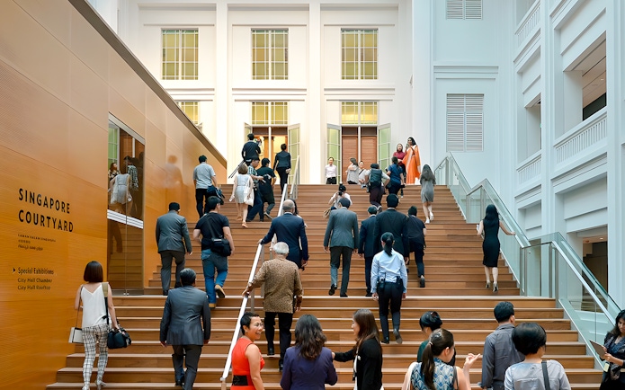 Guests ascending steps at National Gallery Singapore courtyard.