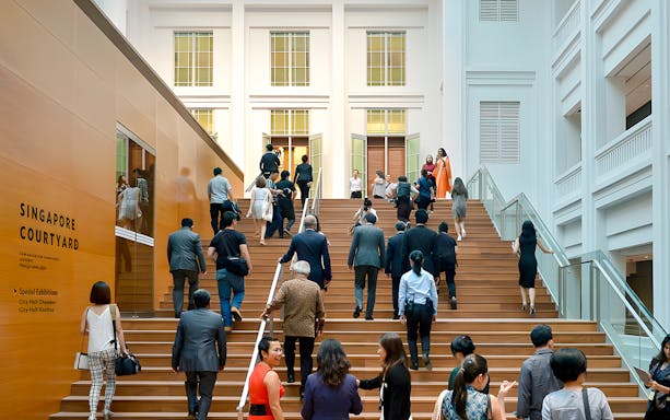 Guests ascending steps at National Gallery Singapore courtyard.