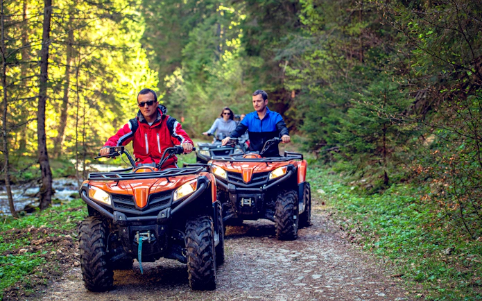 ATV riders on a forest trail adventure.
