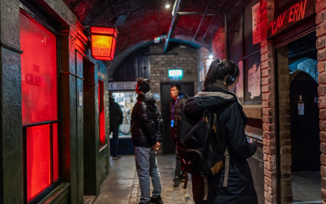Visitors exploring The Beatles Story exhibit interiors in Liverpool.