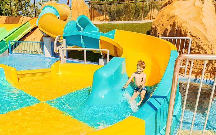 Child enjoying mini turbolance slide at Aquopolis Villanueva de la Cañada.