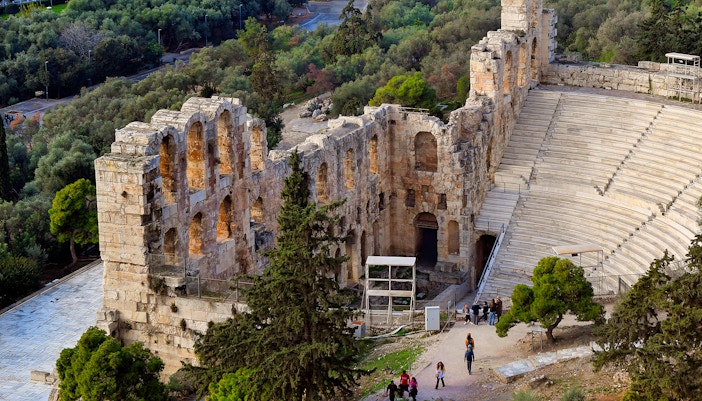 Three story stone facade structure behind the seating area, in ancient Odeon, Greece.