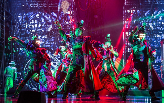 Performers in vibrant costumes dance energetically on stage at Michael Jackson ONE show.