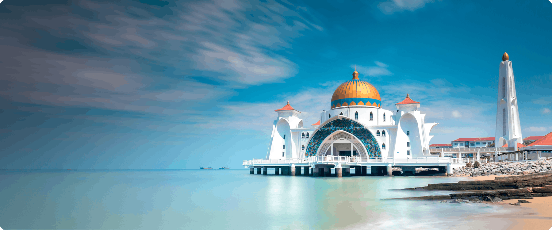Melaka Straits Mosque on the water with clear blue sky.