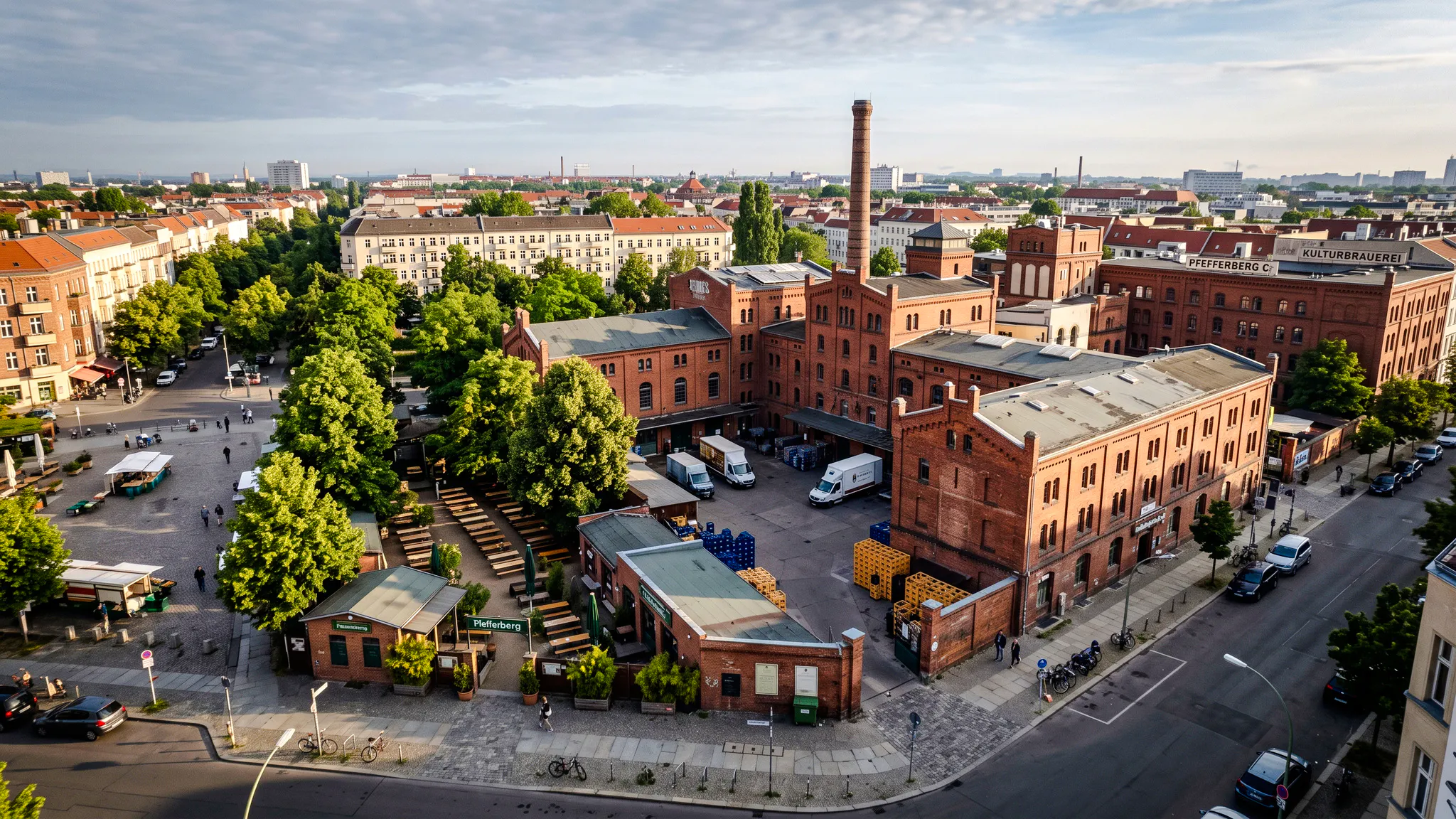 Aerial view of Pfefferberg complex in Berlin, featuring historic red brick buildings and a courtyard.