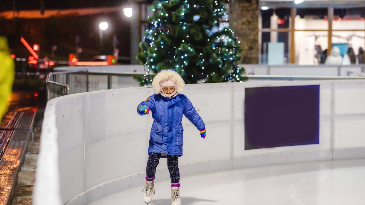 Child ice skating at the Natural History Museum rink in London.