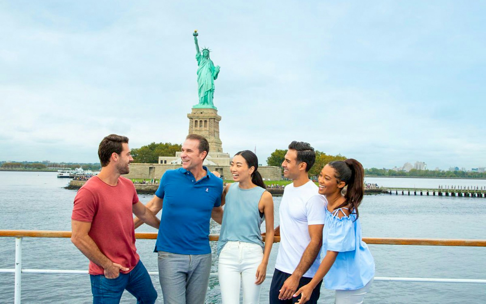 Group enjoying lunch cruise with New York City skyline in the background.