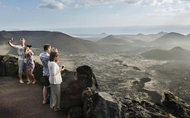 Tourists taking photos at Timanfaya National Park viewpoint, Lanzarote.