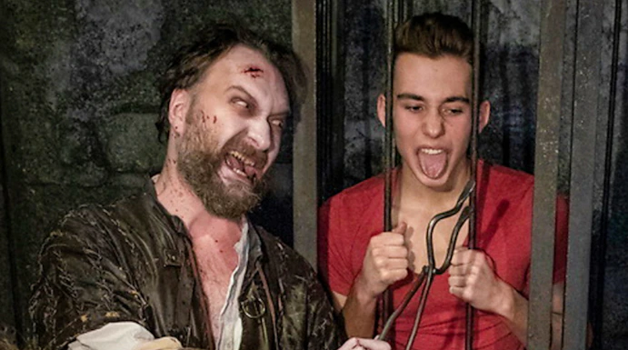 Actor in medieval costume interacting with visitors at Hamburg Dungeon.