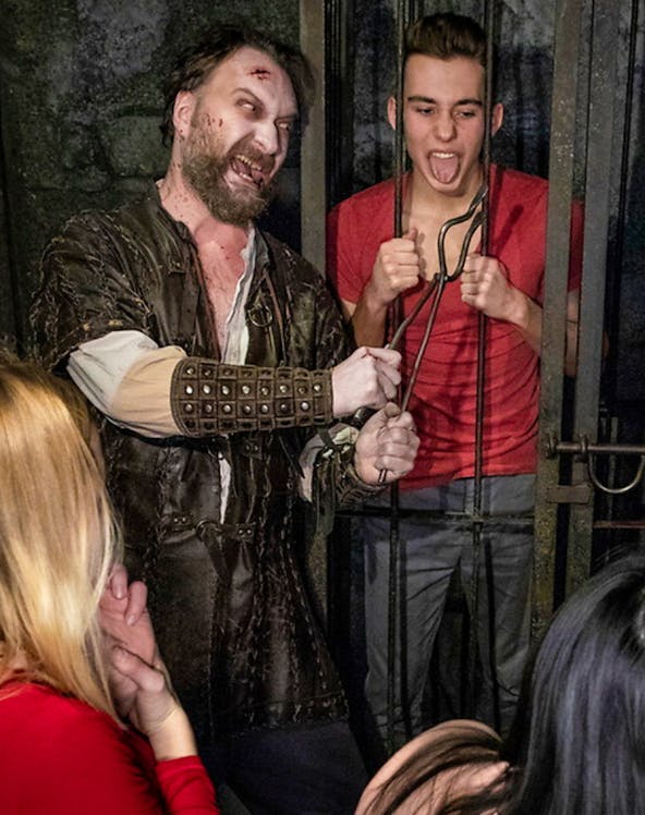 Actor in medieval costume interacting with visitors at Hamburg Dungeon.