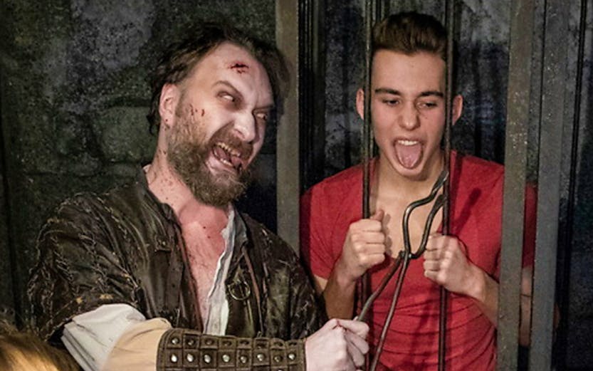 Actor in medieval costume interacting with visitors at Hamburg Dungeon.