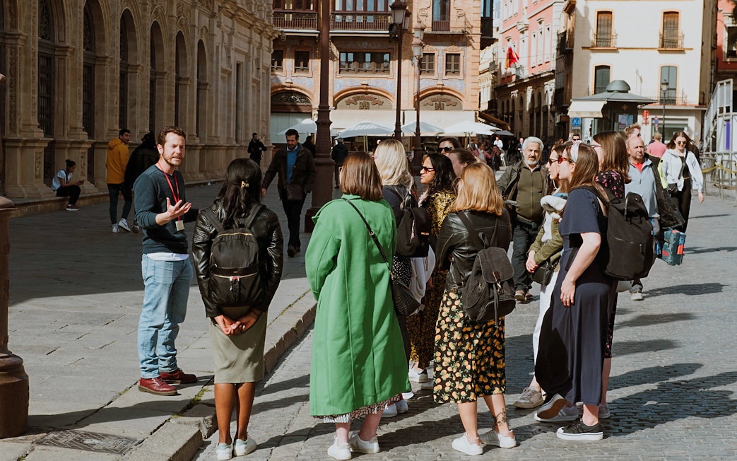 Group on a guided walking tour in Seville, Spain, near historic architecture.