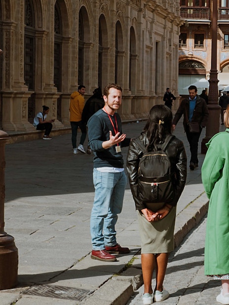 Group on a guided walking tour in Seville, Spain, near historic architecture.