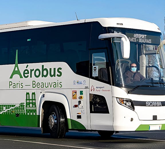 Shuttle bus labeled "Aérobus Paris-Beauvais" on road near Beauvais Airport.