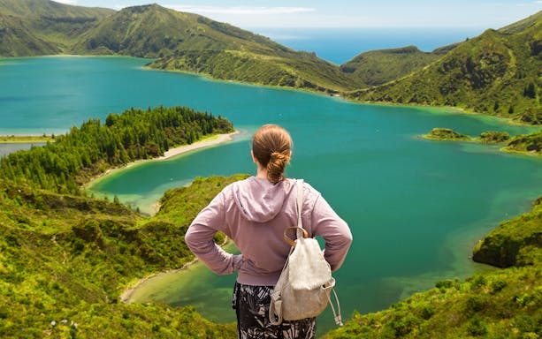 Hiker overlooking Lagoa do Fogo in Azores during a full-day hike.