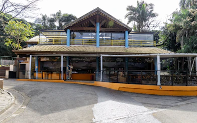 Restaurant entrance at São Paulo Zoo with outdoor seating and tropical surroundings.