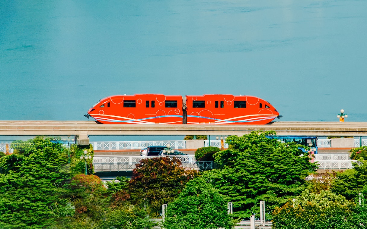 Red monorail traveling on Sentosa Island, Singapore.