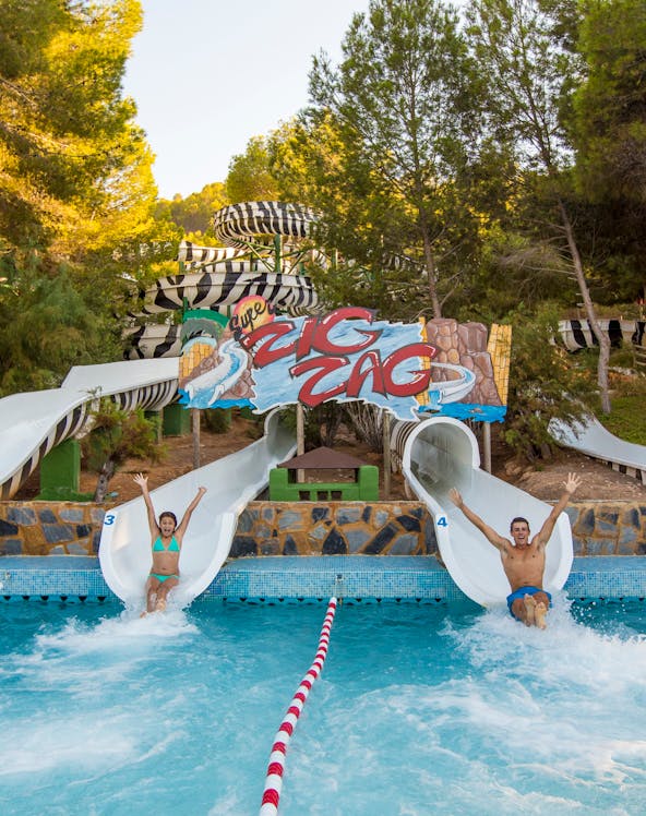 Two people sliding down water slides at Aqualandia Benidorm.