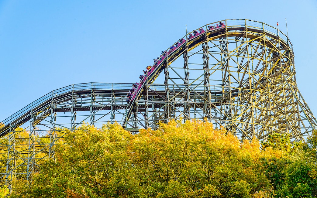 Roller coaster at Everland theme park with vibrant autumn trees.
