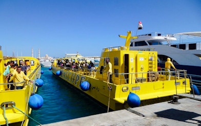 Yellow Royal Seascope submarines docked at a marina, preparing for a cruise with snorkel stop.