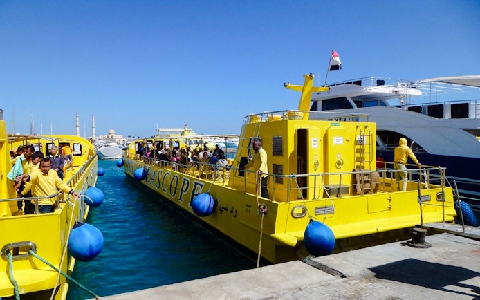 Yellow Royal Seascope submarines docked at a marina, preparing for a cruise with snorkel stop.