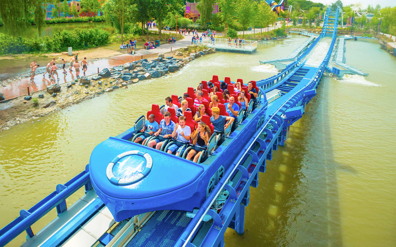 Panoramic view of Walibi Belgium park with roller coasters and lush greenery.