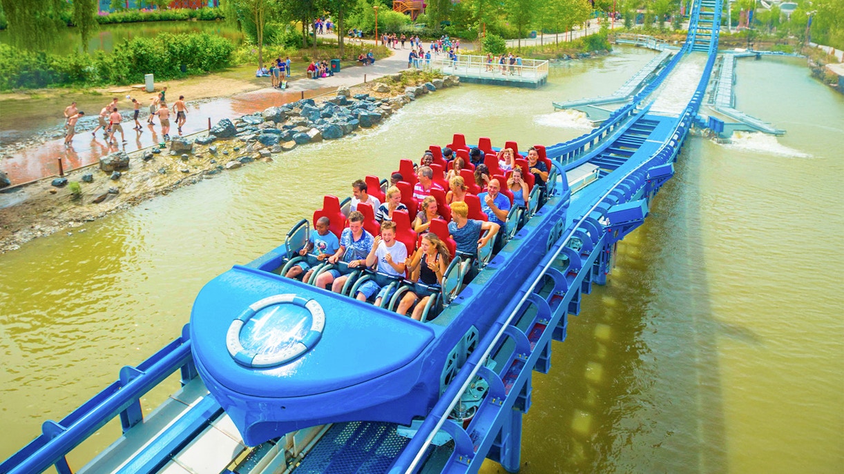 Panoramic view of Walibi Belgium park with roller coasters and lush greenery.