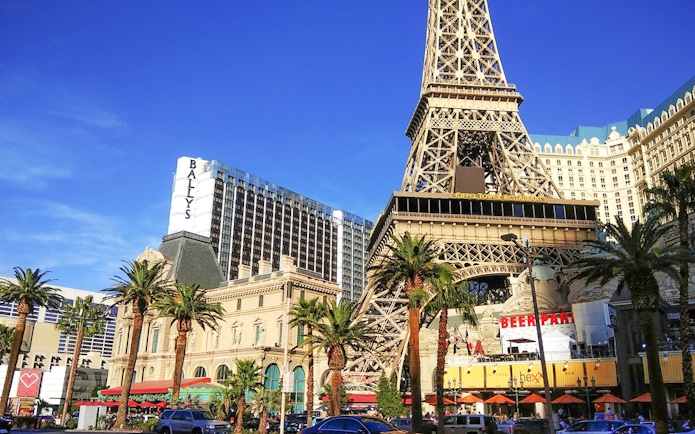Eiffel Tower replica in Las Vegas with nearby hotels and palm trees.