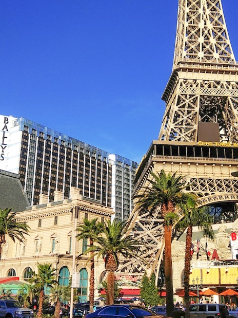 Eiffel Tower replica in Las Vegas with nearby hotels and palm trees.