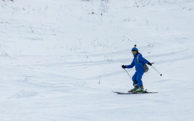 Skier descending snowy slope in Shahdag, Gusar, Azerbaijan during winter sports tour.