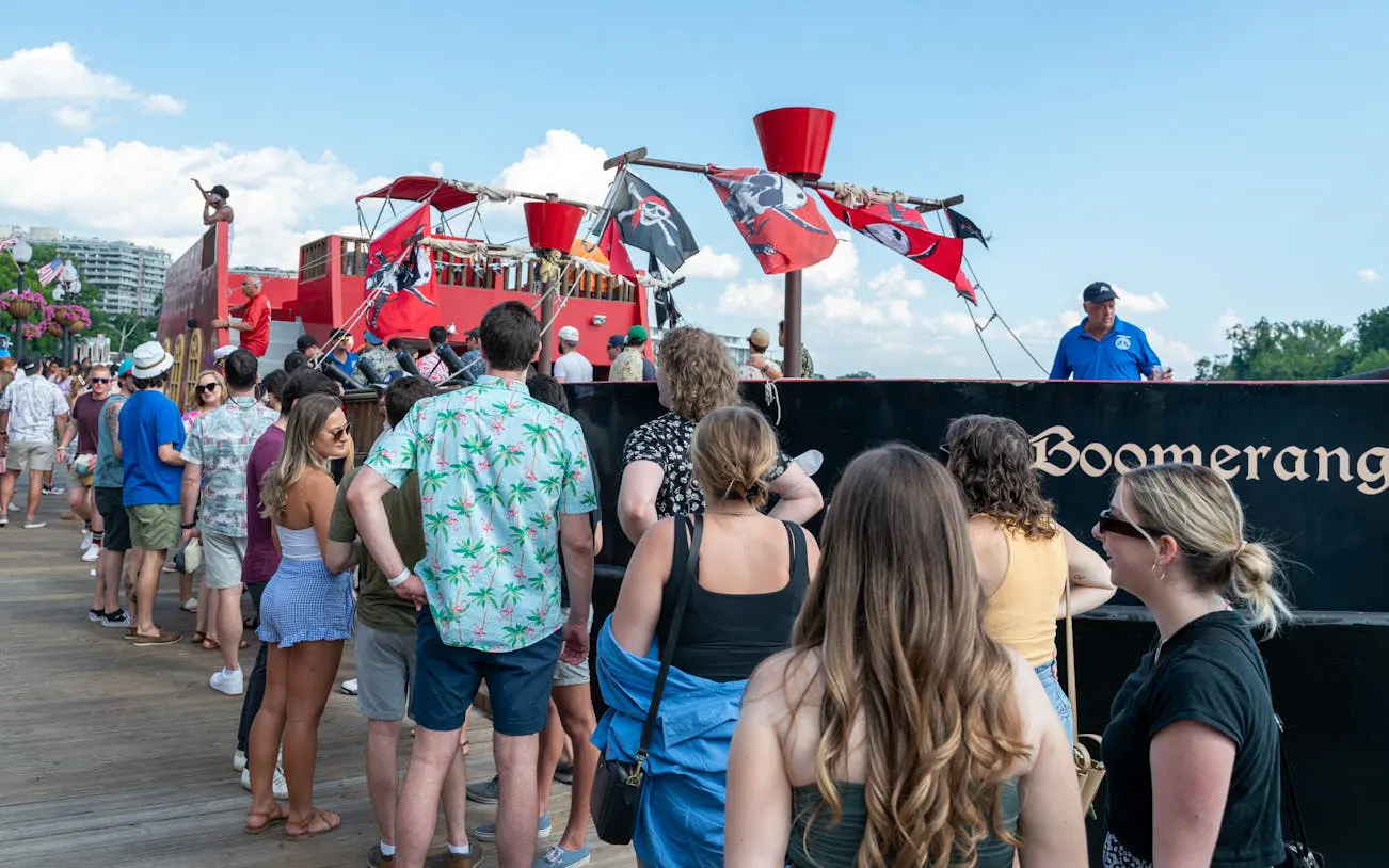 People boarding the Boomerang Pirate Ship for a 21+ party cruise with views of DC monuments.
