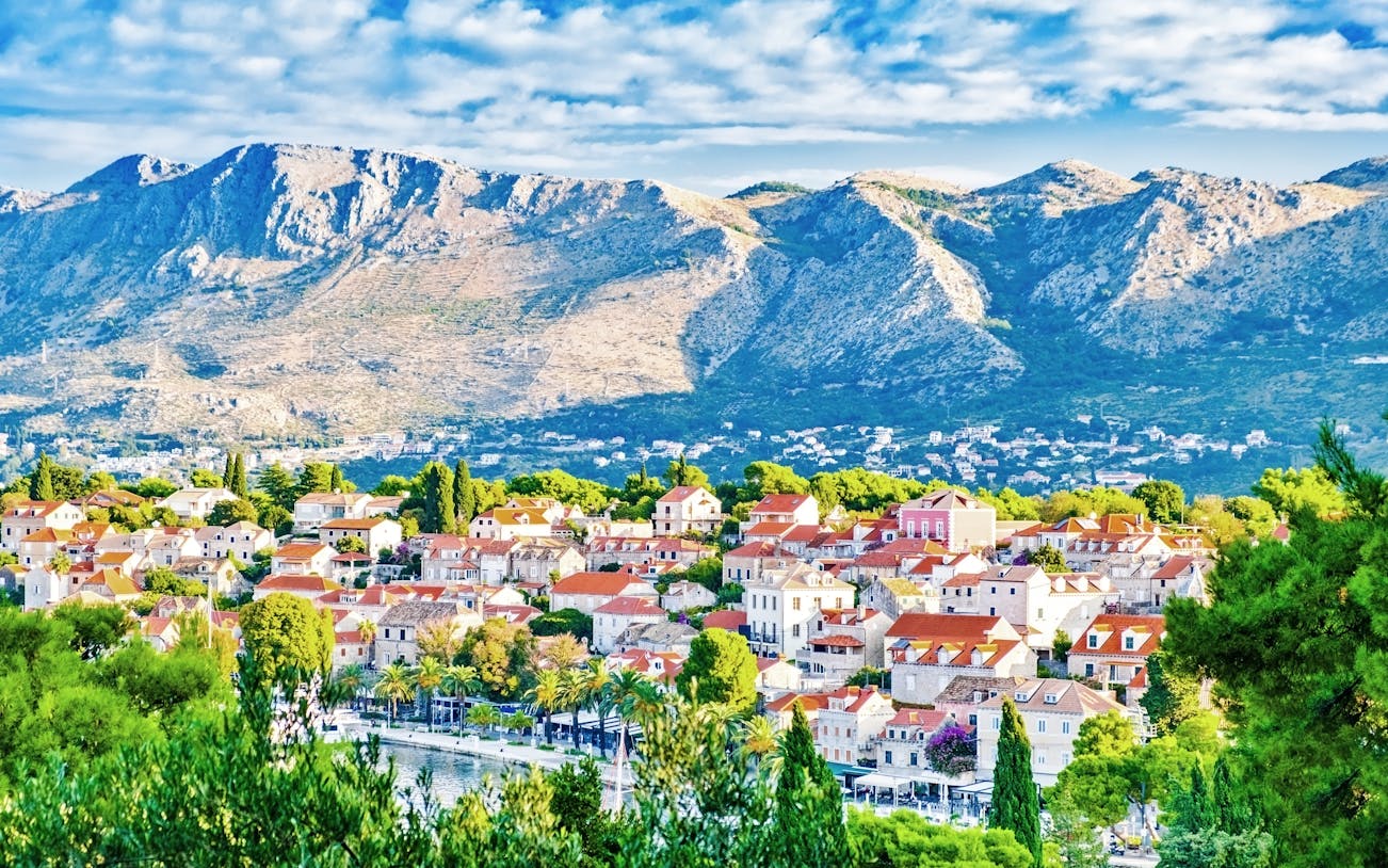 Panoramic view of Cavtat town with red-roofed buildings and mountains, south Dalmatia, Croatia.